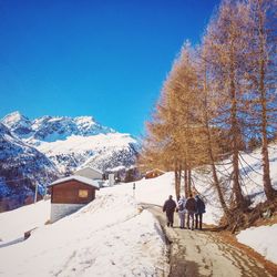 Rear view of people walking on footpath during winter