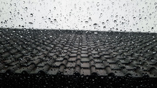 Full frame shot of wet glass window during rainy season