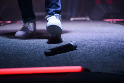 Low section of man standing by microphone on stage