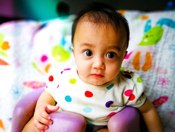 Close-up portrait of cute baby girl drooling at home