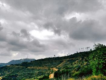 Scenic view of field against cloudy sky