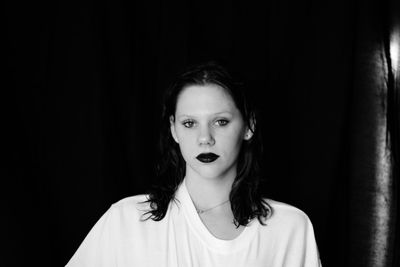 Portrait of beautiful young woman against black background