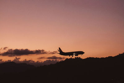 Silhouette of airplane flying in sky