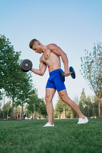 Full length of shirtless man looking at camera