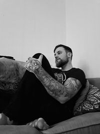 Young man sitting on sofa at home