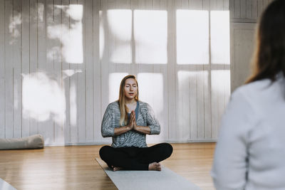 Woman meditating in yoga studio