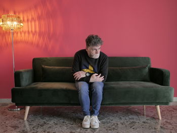 Young man sitting on sofa at home