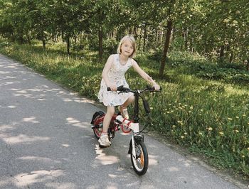 Portrait of young woman riding bicycle on field