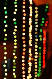 Close-up of illuminated light bulbs hanging at night