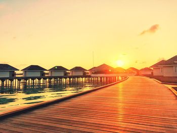 View of swimming pool by sea against sky during sunset