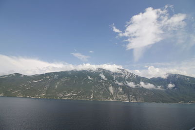 Scenic view of lake by mountains against sky