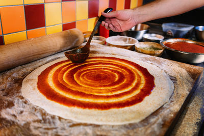 Close-up of man preparing pizza in kitchen at restaurant