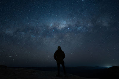 Silhouette man standing on field against sky at night