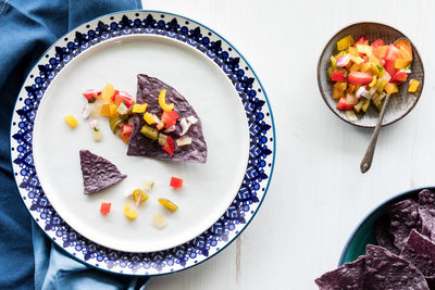 Top down view of a serving of blue corn tortillas with homemade salsa.