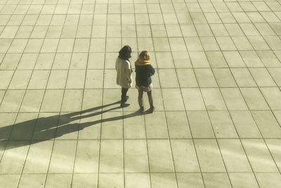 High angle view of friends walking on tiled floor