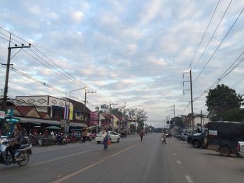 View of city street against cloudy sky