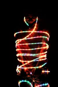 Low angle view of illuminated christmas lights against black background