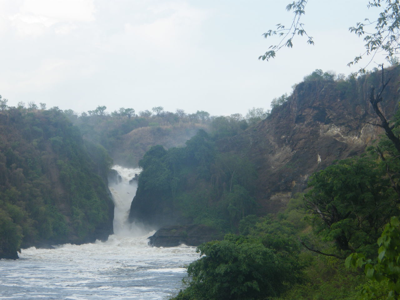 SCENIC VIEW OF WATERFALL AMIDST TREES AGAINST SKY