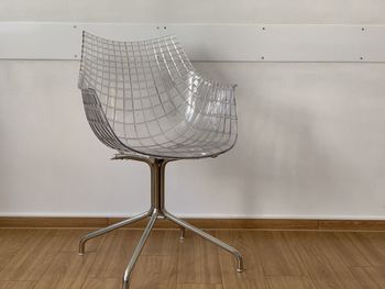 Close-up of empty chair by wall at home