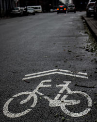 Close-up of arrow and bicycle symbol on road