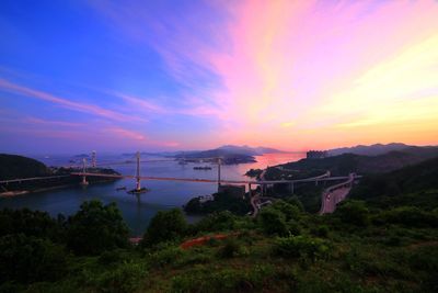 Scenic view of river against cloudy sky during sunset