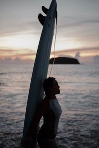 Woman standing at beach during sunset