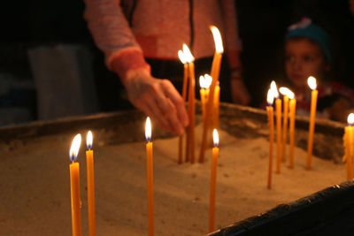 Close-up of hand holding lit candles