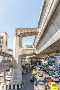 Traffic on road in city against clear sky