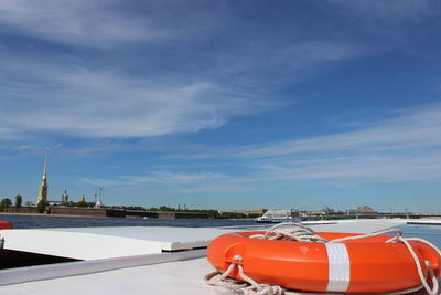 Boat moored in city against sky