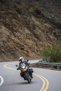 Woman on touring motorbike riding twisting road in argentina