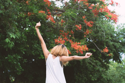 Rear view of woman standing by tree