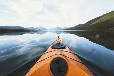 Kayak sailing on lake against sky at glacier national park