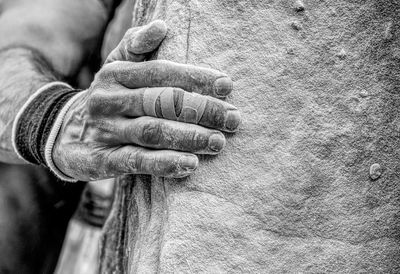 Cropped hand of man holding stone