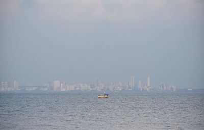 Boat sailing in sea against clear sky