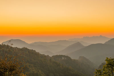 Scenic view of mountains against orange sky