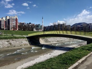 Bridge over river against buildings in city