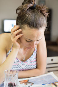 Woman reading newspaper at home