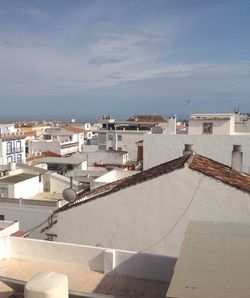 High angle view of buildings by town against sky