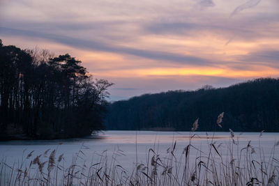 Scenic view of frozen lake against sky during sunset