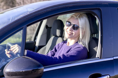 Side view of man driving car