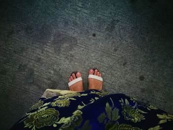 Low section of woman standing on footpath