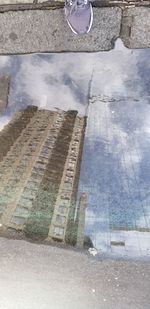 High angle view of puddle with reflection on street