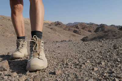 Low section of senior man wearing shoes in the desert 
