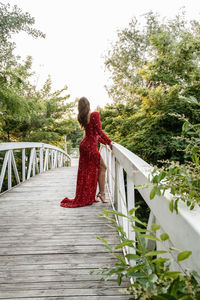 Side view of woman standing on footbridge