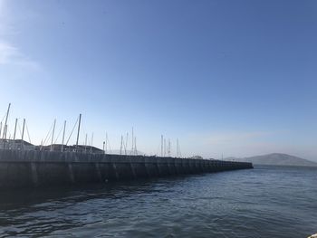 Sailboats in sea against clear blue sky