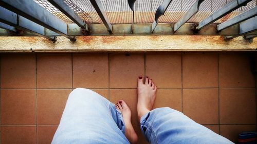 Low section of feet relaxing on a balcony