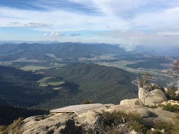 The view of landscape from mount buffalo on a bright day under cloudy skies.