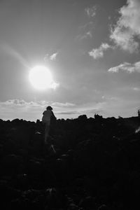 Low angle view of silhouette man standing on cliff against sky