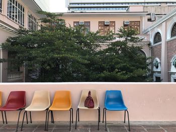 Empty chairs on building terrace in city