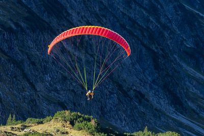 Person paragliding against mountain